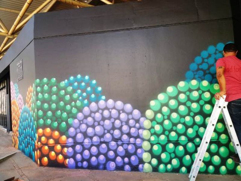 Artista Helder Oliveira grafita fachada do Poliesportivo 