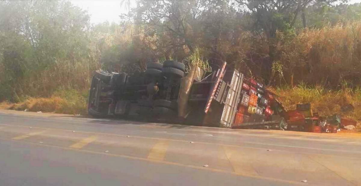 Caminhão com carga de manga tomba no trevo de acesso à rodovia MG 439